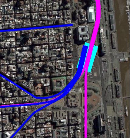 La nueva estación Colón, bajo la actual Av. Rosales, sobre el túnel (en magenta) que viene de Retiro y se bifurca hacia Constitución y hacia Once (parcialmente cubierta por los trazados azules del subte). Las líneas azules representan las actuales líneas de subte, donde las líneas A, D y E se han extendido para llegar a la estación Colón. No se ha representado la posible extensión de la línea E hasta Retiro, que compartiría el túnel, aunque no la vía, con el enlace en magenta, ya marcado, o podría ir bajo Alem. En todo caso, de no ofrecerse un servicio de la línea E (o cualquiera de las otras) hasta Retiro, el enlace ferroviario debería prever una vía de doble trocha para la entrada/salida para mantenimiento de los coches de las líneas de subte fuera del horario de servicio regular.